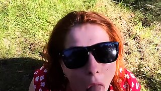 Kinky redhead with big tits gives a blowjob outdoors