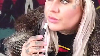 Blonde lady smokes an electronic cigarette