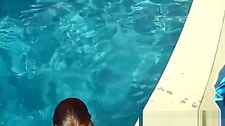 Lexxi Luxe swims half nude in a pool.