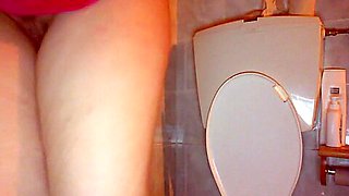 Young girl masturbates on the toilet with a big rubber dildo