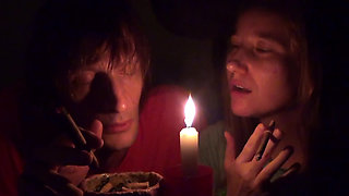 Couple smoke next to candle
