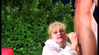 Mature and hairy woman gives a blowjob outdoor