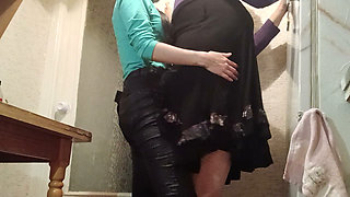 I'm fucking my married neighbor hard with a strap-on in the kitchen while her husband watches TV