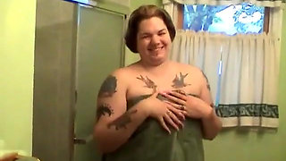 Tattooed fat chick strips to wash her tits and cunt in the shower