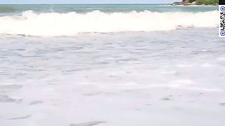 A brown-haired chick in a white bathing suit top gives a
