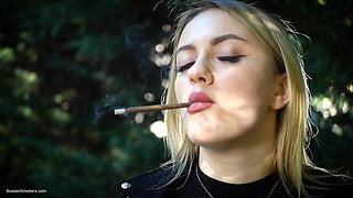 Hot Blonde Babe Smoking Two Black Cigarettes in Nature