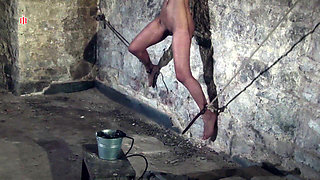 Hanging at the Wall with Her Legs Spread Wide Apart the Female Prisoner Is Made Hot by Lashes